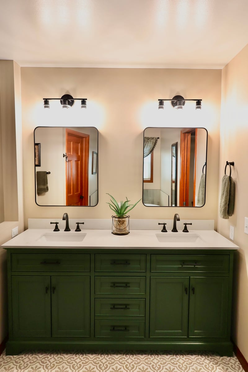 Double vanity with green cabinets and matte black fixtures in Lowell bathroom remodel