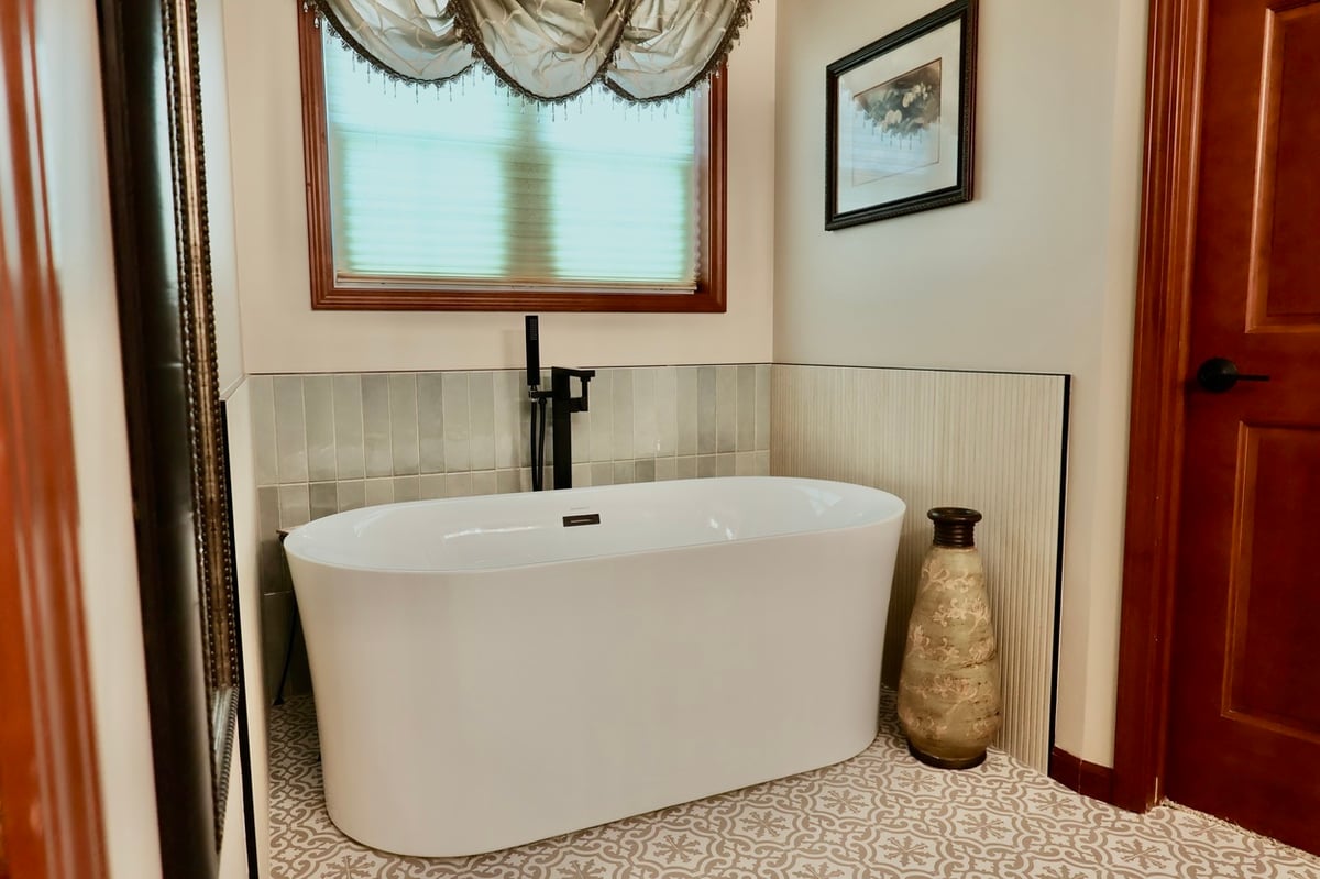 Freestanding tub with black floor-mounted faucet in Lowell bathroom remodel