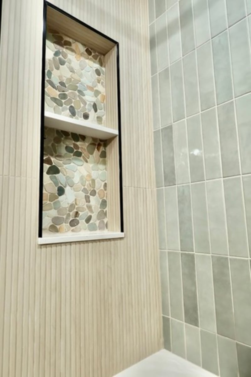 Pebble tile shower niche with white shelf detail from Lowell bathroom remodel