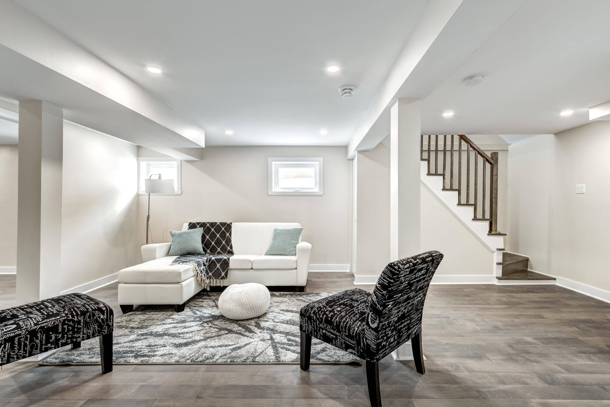 Spacious basement living area with sleek decor and ample lighting by Clear Contractors in Northwest Indiana