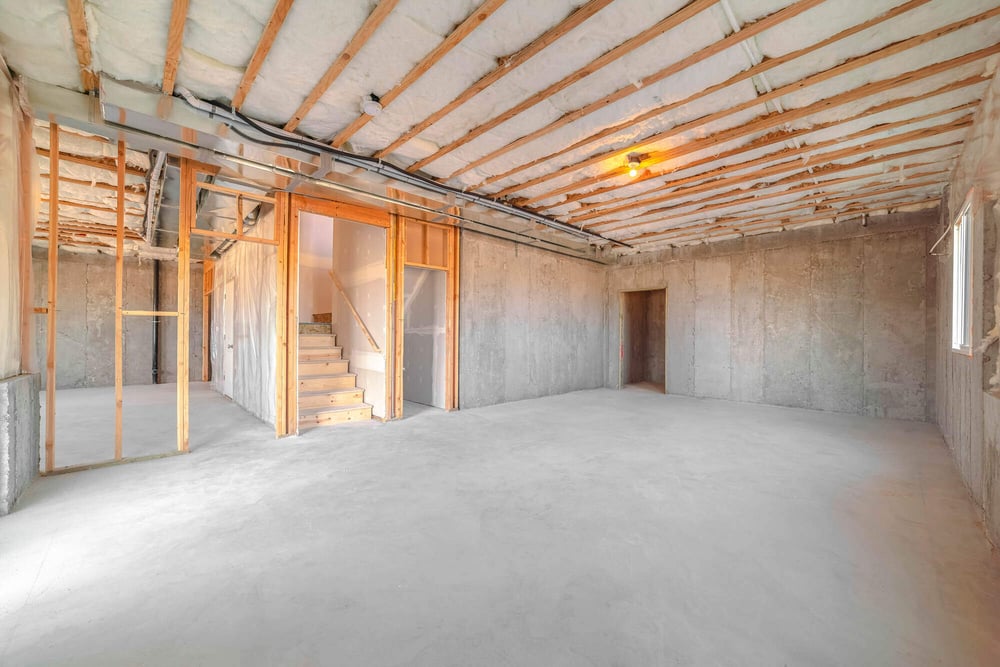 Unfinished basement with exposed insulation and framing, ready for renovation by Clear Contractors in Northwest Indiana