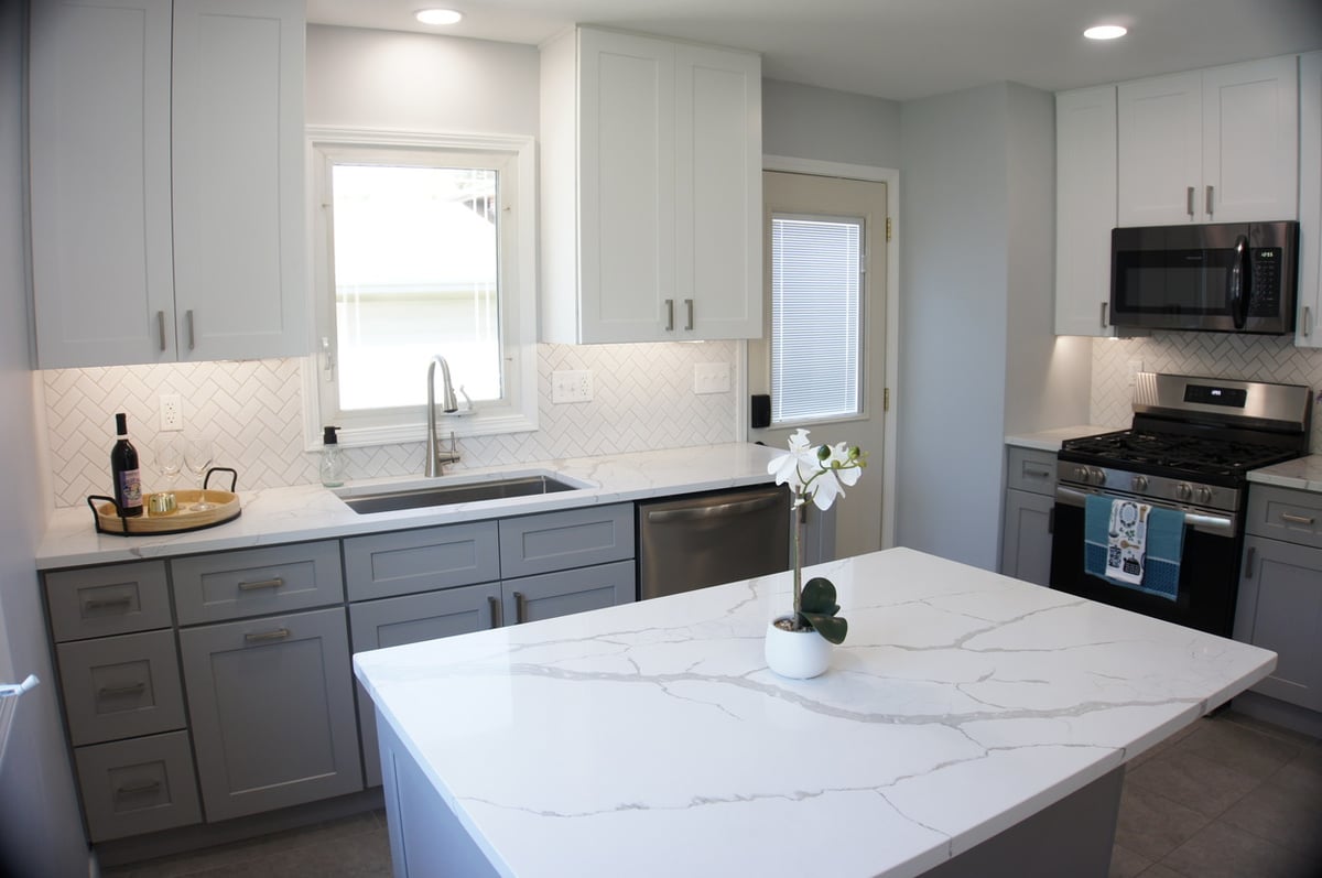 Kitchen with gray lower cabinets, white uppers, and stainless appliances for Kitchen Remodel in Munster