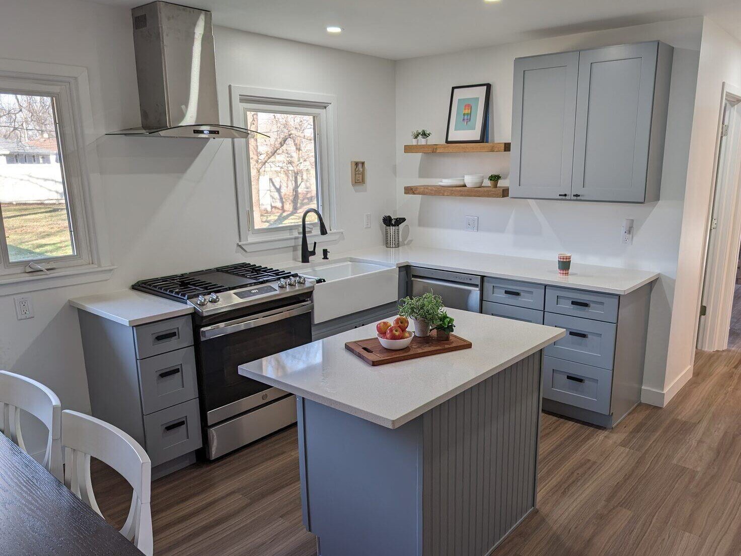 Bright kitchen remodel with gray cabinets, farmhouse sink, and a modern island by Clear Contractors in Northwest Indiana